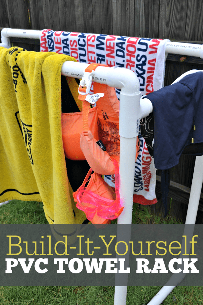 This picture shows a DIY Pool Towel rack made out of PVC material, white in color, showing pool towels, bathing suits, and other accessories hanging over the side to dry. 