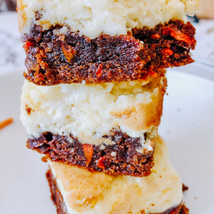 A stack of carrot cheesecake bars on a white plate