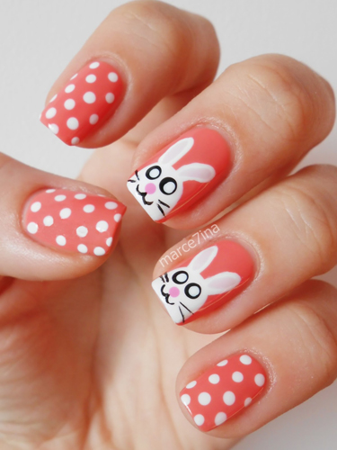 white polka-dotted coral nails with white easter bunny accent nails