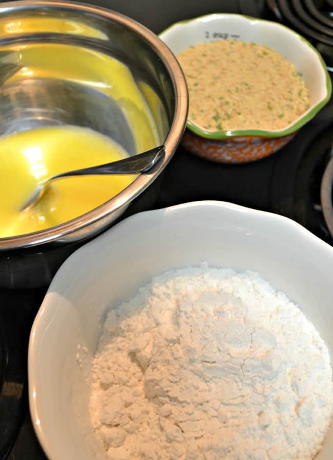 Different Bowls are filled with the egg mixture, Italian Breadcrumbs, and Flour.