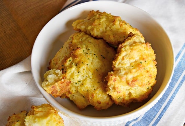 White bowl stacked with cheddar bay biscuits