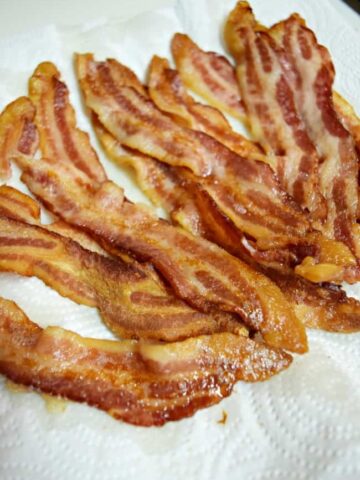 If you have ever wondered how to cook bacon in an oven then check out this perfect bacon recipe. Made easily in the oven for a quick no mess clean up. Best way to cook a bunch for the whole crowd.