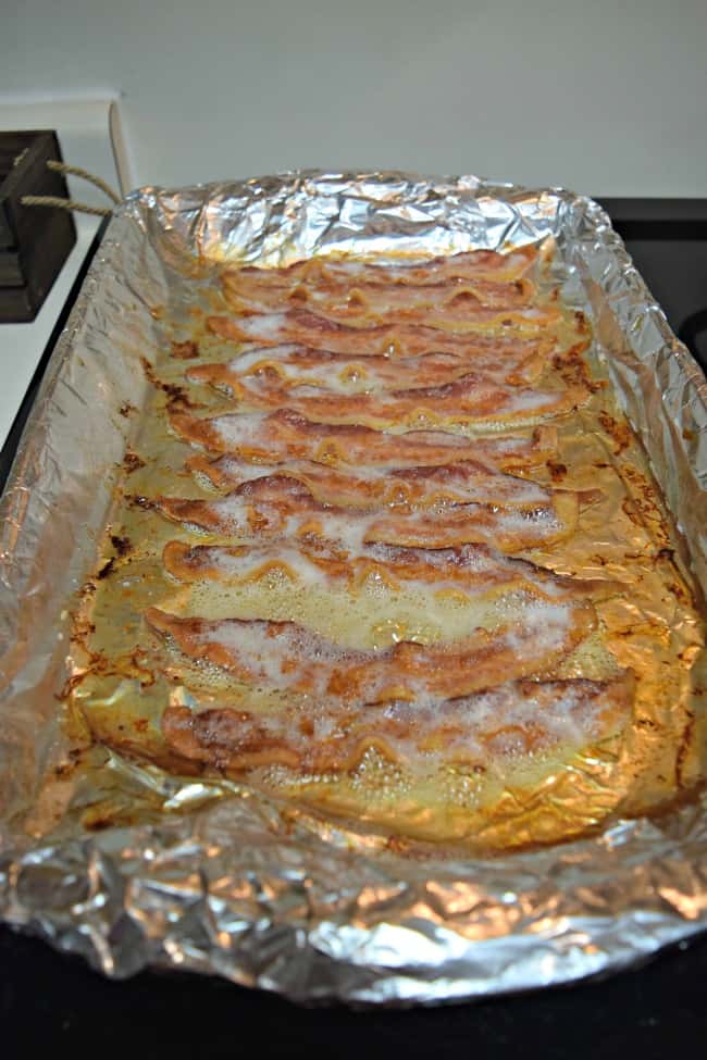 cooked bacon on a foil-lined backing pan