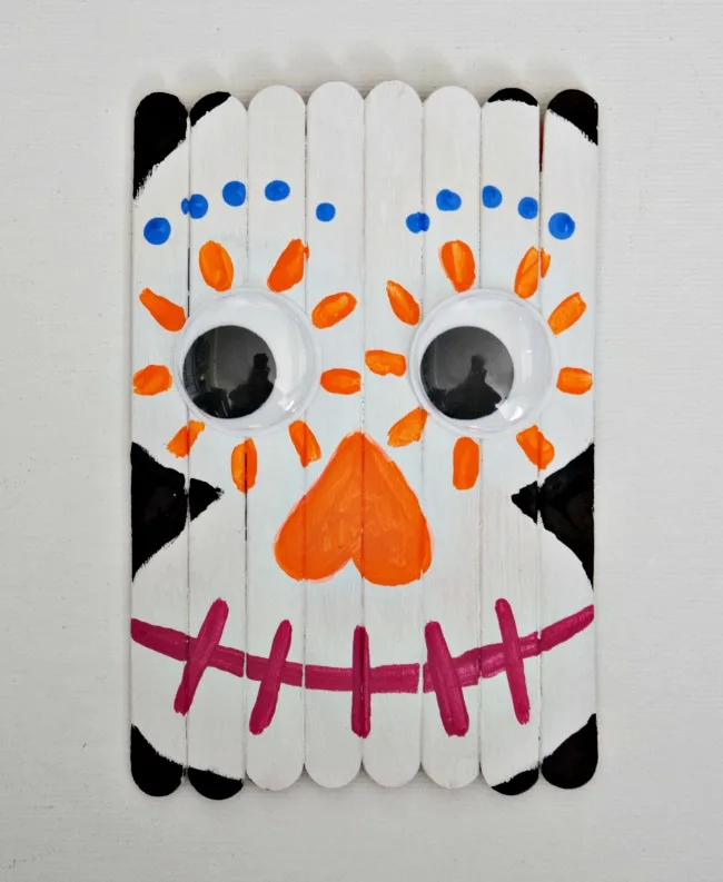 Celebrate the Day of the Dead with this fun and colorful Popsicle Stick Sugar Skull. A great craft for the new Disney movie, Coco!