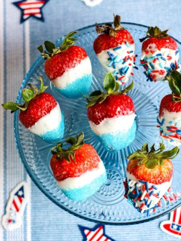 This photo features red strawberries decorated in white chocolate and covered with blue and americana sprinkles. They make perfect patriotic strawberries!