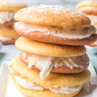 This photo features a plate with pineapple cake mix whoopie pies stacked on top of each other.