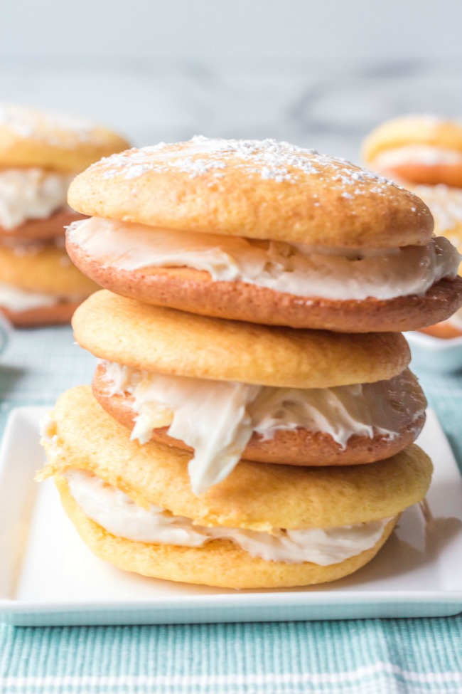 This photo features a plate with pineapple cake mix whoopie pies stacked on top of each other.