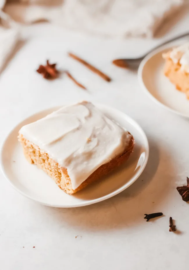 This photo features a slice of homemade pumpkin cake on a white plate.