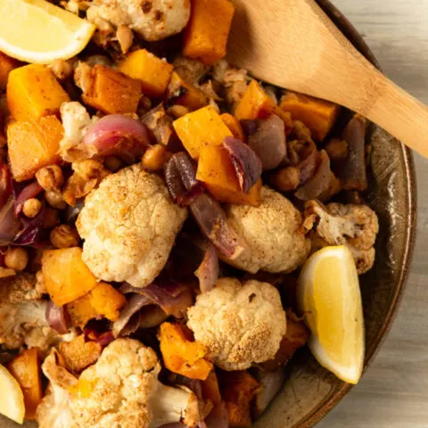 This photo features a plate of roasted butternut squash and cauliflower side dish.
