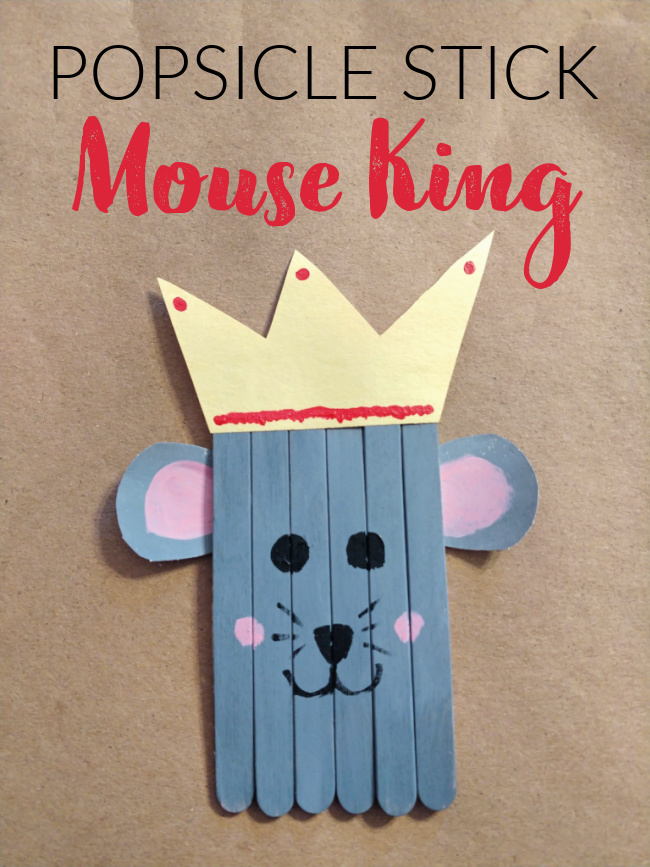 This photo features a popsicle stick mouse king craft that was created by kids placed on top of a brown background.