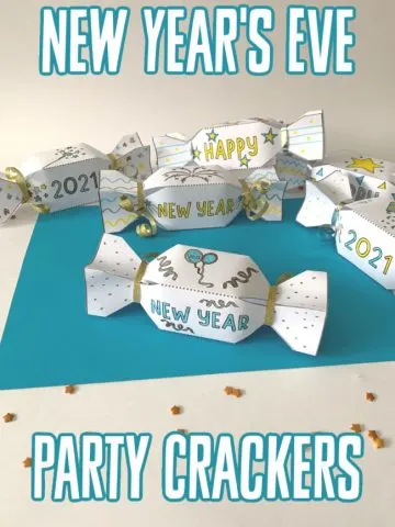 This photo features a blue paper background with some New Year's Eve Party Crackers colored and put together on top.