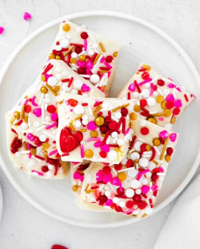 This photo features a white plate of white chocolate fudge.