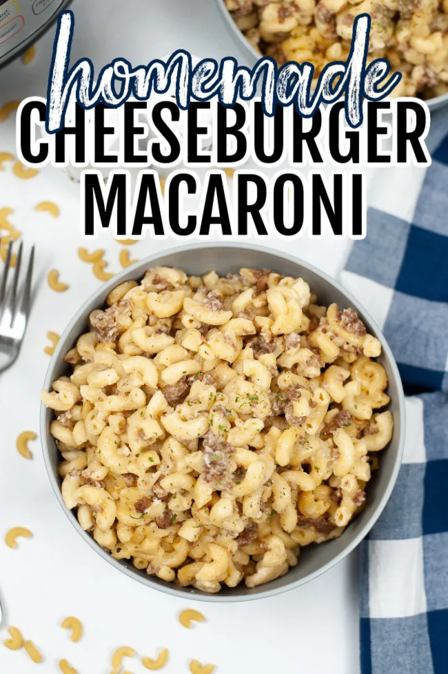 Homemade Cheeseburger Macaroni in a bowl with a blue and white tea towel to the right and a fork on the left.
