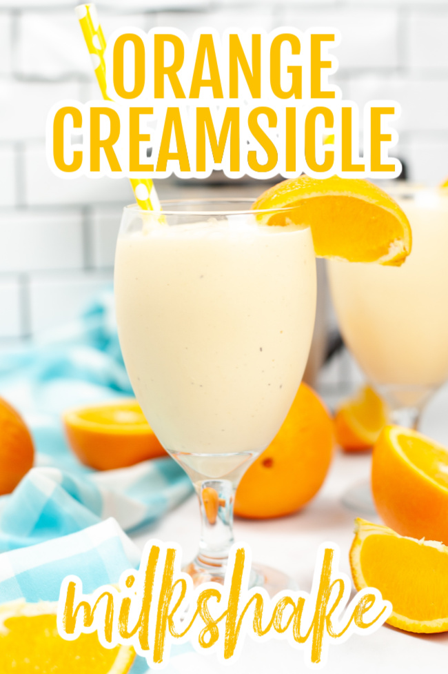Orange Creamsicle Milkshake in a champagne style glass with a straw and slice of orange on the side.
