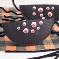 Paper Plate Rockin' Spider Craft on a black and orange background.
