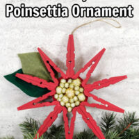 red painted clothespin poinsettia ornament on a white background