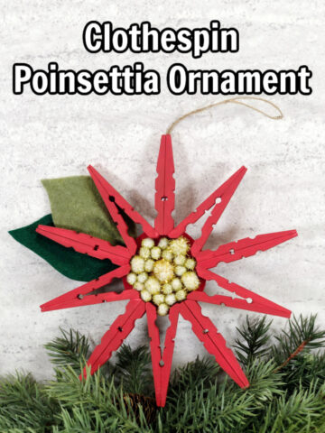 red painted clothespin poinsettia ornament on a white background