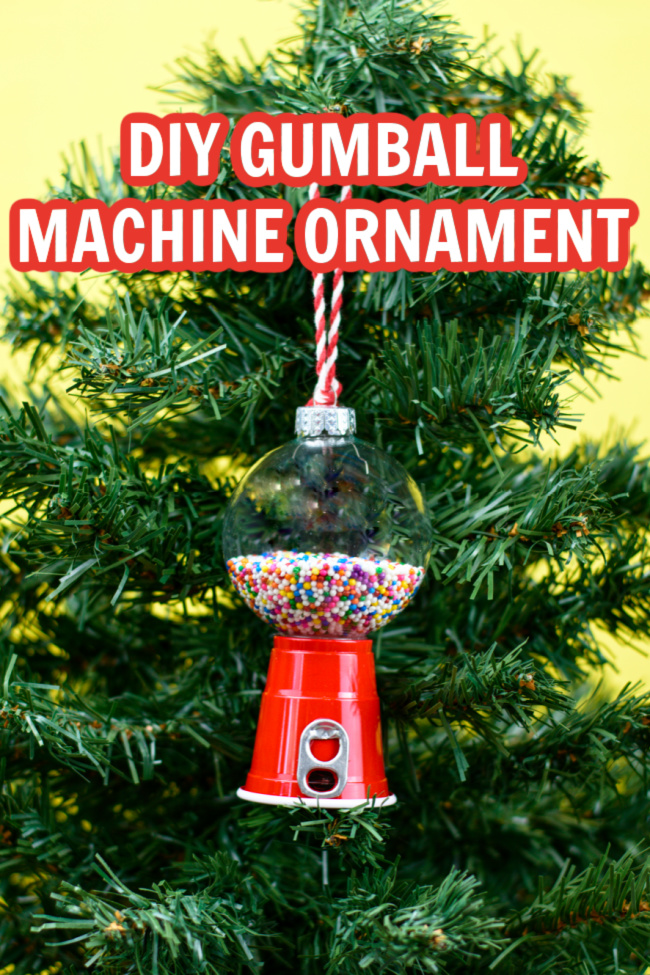 DIY Gumball Machine Ornament hanging on a green Christmas tree. The ornament is made from a mini red solo cup and a plastic clear ornament.