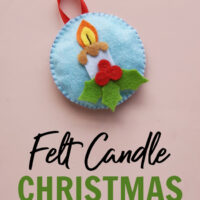 Felt Christmas candle ornament made by sewing pieces of felt together on a pink background