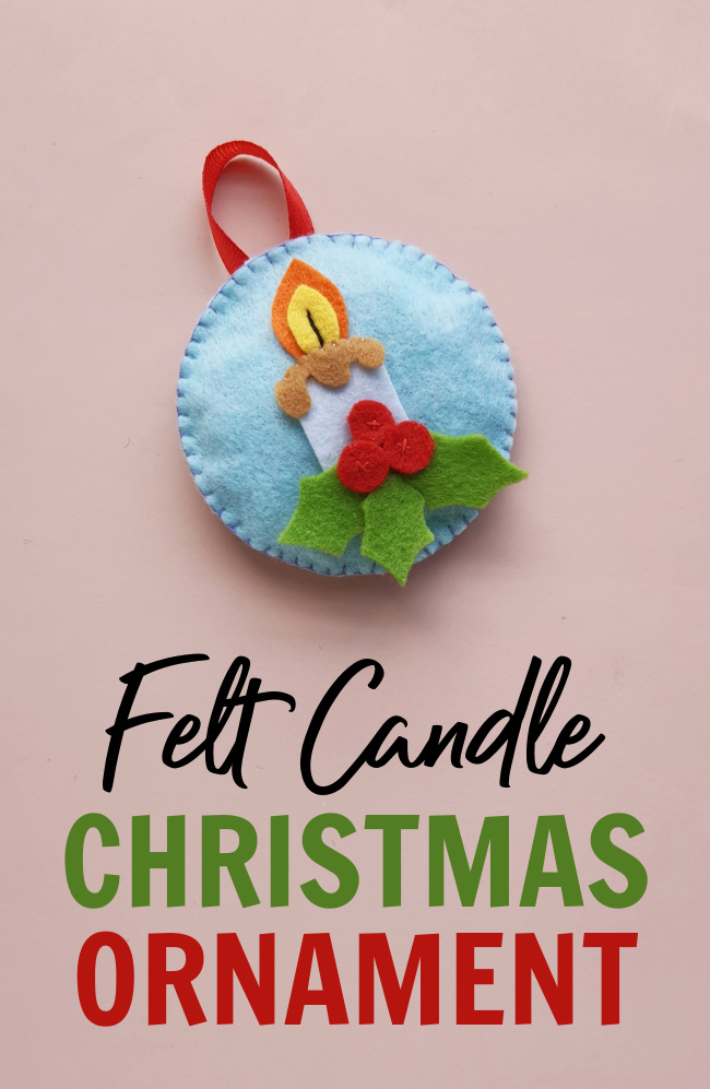 Felt Christmas candle ornament made by sewing pieces of felt together on a pink background
