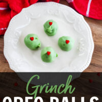 Grinch Oreo Balls with a red heart in the center on a white plate