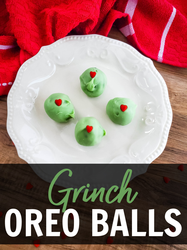 Grinch Oreo Balls with a red heart in the center on a white plate