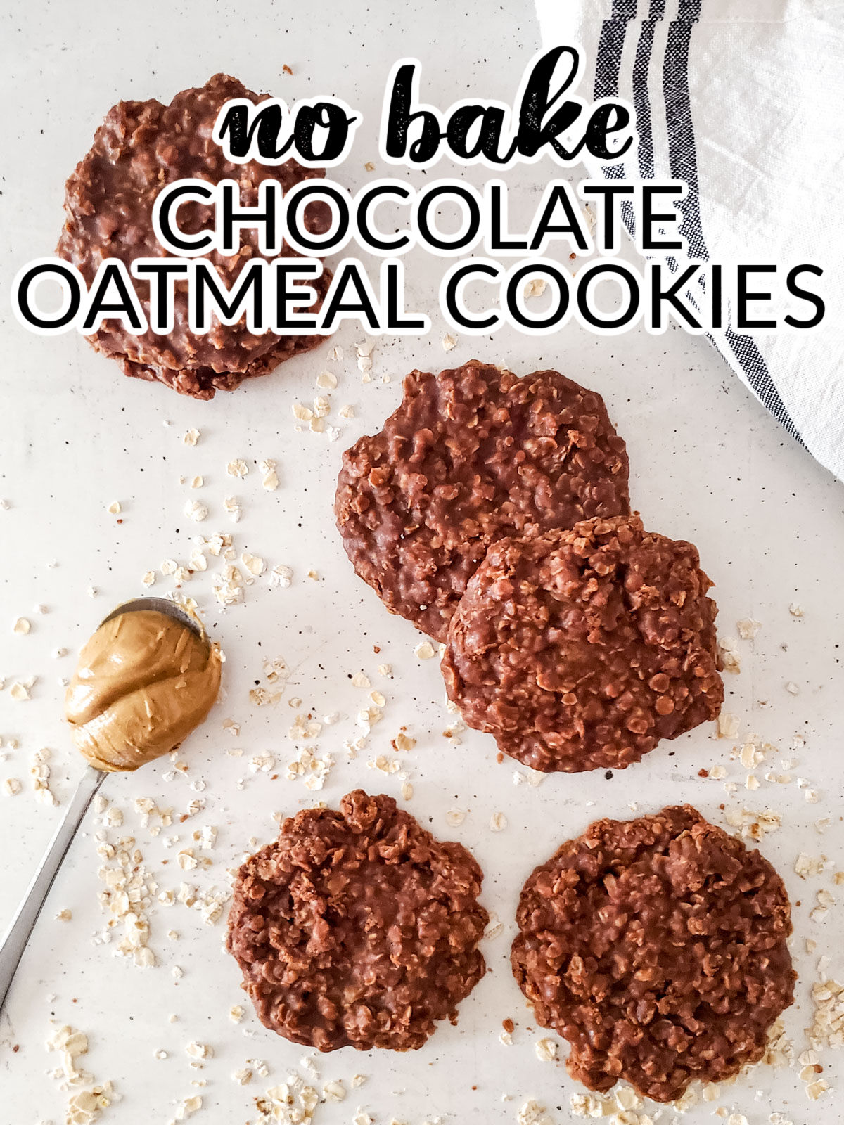 No Bake Chocolate Oatmeal Cookies on a marble countertop with a spoon of peanut butter on the side.