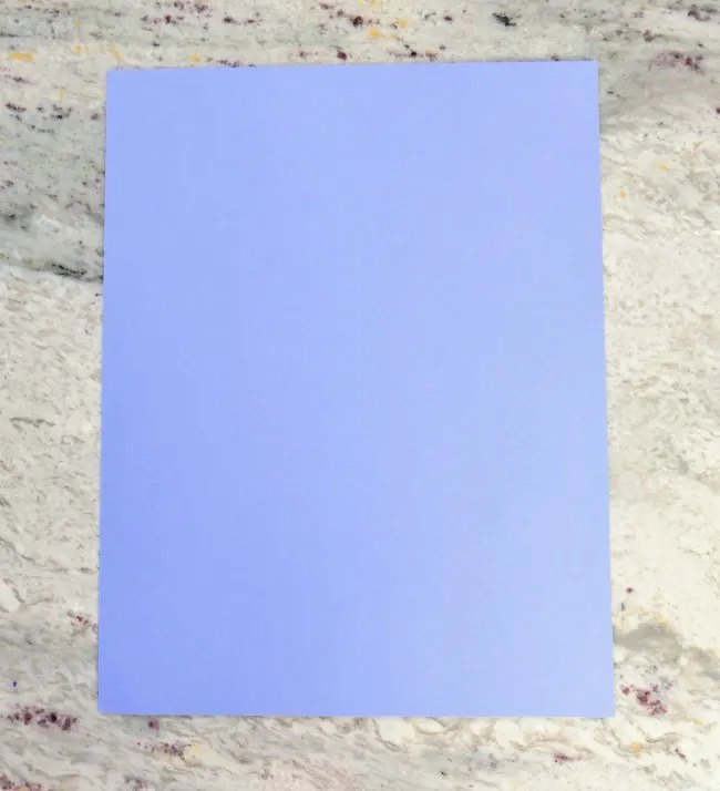 Blue construction paper on a marbled background