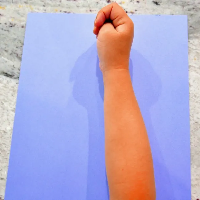 Forearm laid on the blue construction paper