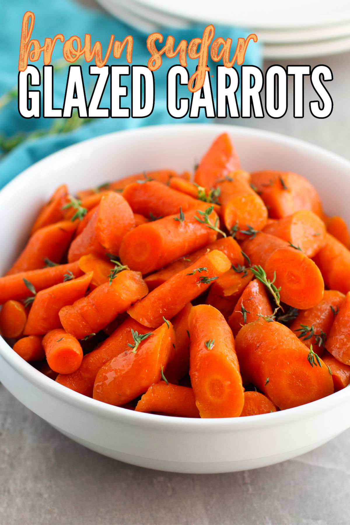 Brown Sugar Glazed Carrots in a white bowl with a blue tea towel on the side