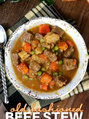 Old Fashioned Beef Stew in a white bowl with a spoon set to the side.