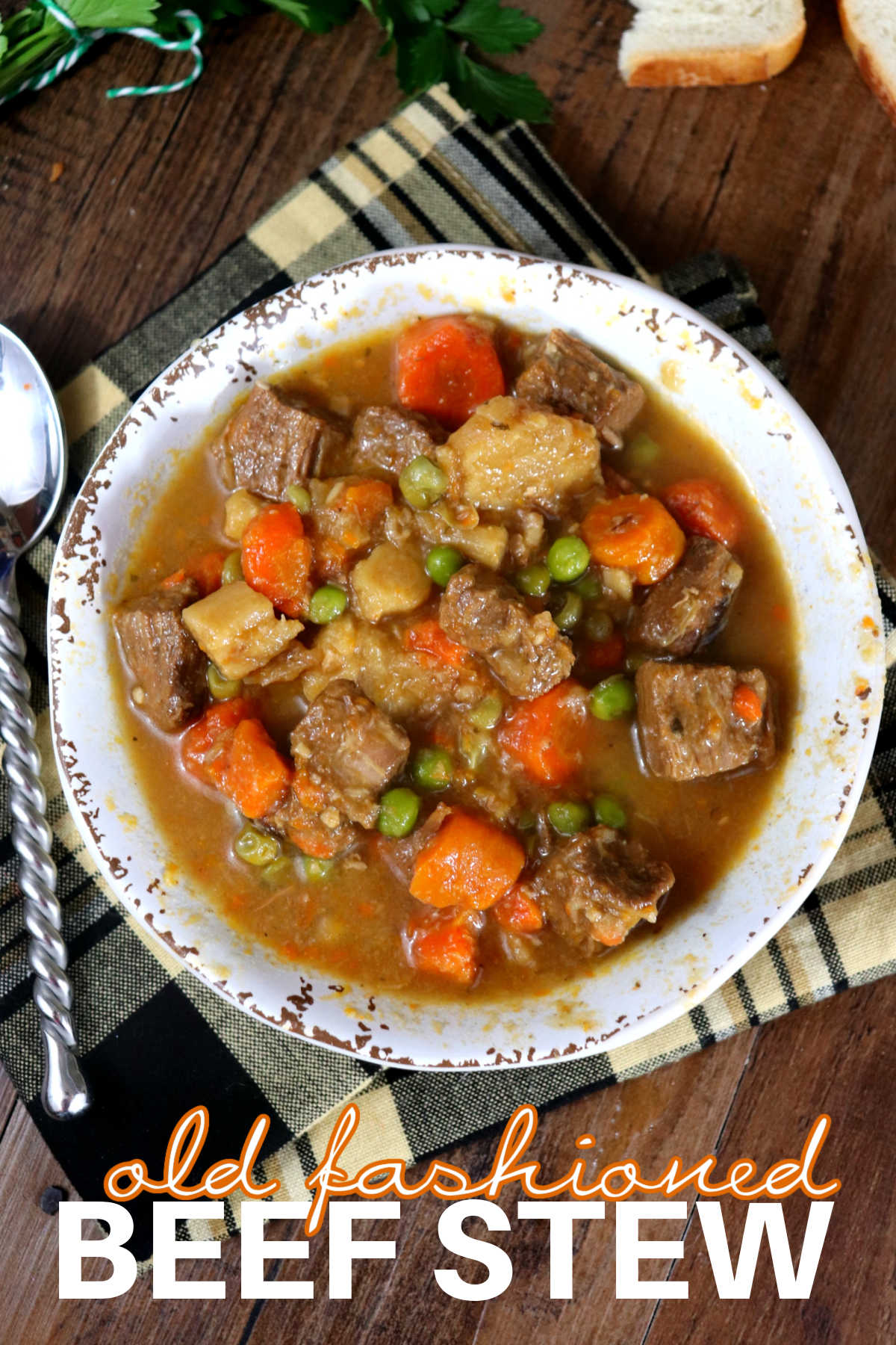 Old Fashioned Beef Stew in a white bowl with a spoon set to the side.