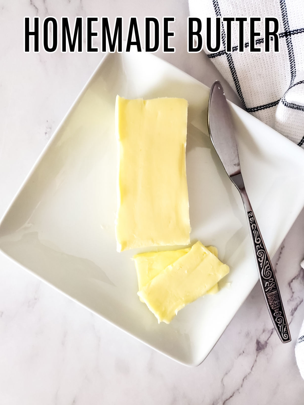 Homemade Butter on a white dish with a decorative knife beside it.