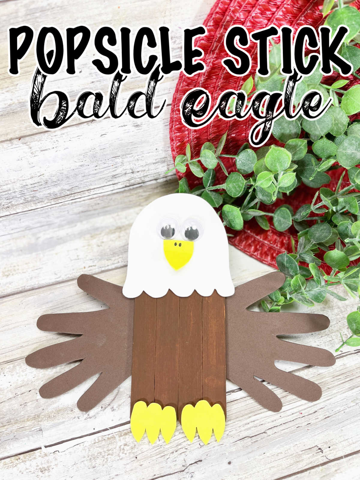 Popsicle Stick Bald Eagle craft on a white shiplap background.