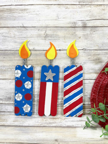 Popsicle Stick Firecracker craft on a white shiplap background