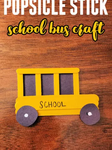 Painted Popsicle Stick School Bus Craft on a wood background.