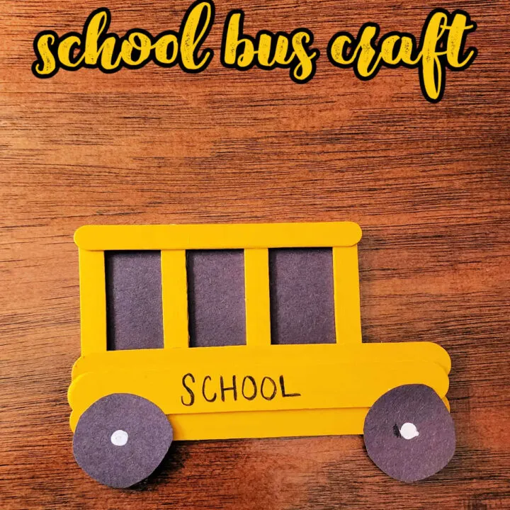 Painted Popsicle Stick School Bus Craft on a wood background.