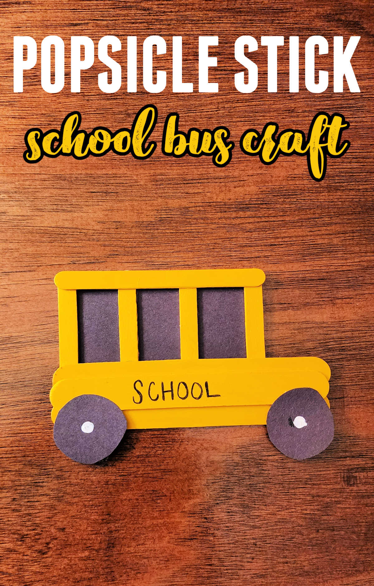 Painted Popsicle Stick School Bus Craft on a wood background.