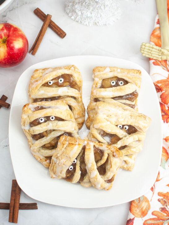 Mummy Apple Danish Pies on a white plate with red apple in the background